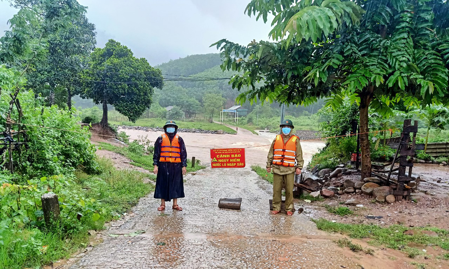 Cán bộ Đồn Biên phòng CKQT Cha Lo lập rào chắn, canh gác đảm bảo an toàn tại tuyến đường vào bản Ka Ai, xã Dân Hóa, huyện Minh Hóa, tỉnh Quảng Bình bị ngập lụt chia cắt.