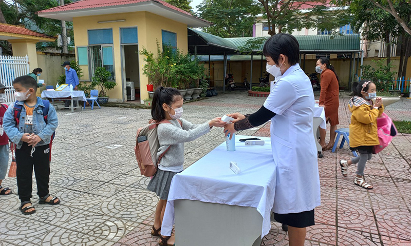 Tại Trường TH Hải Đình, học sinh thực hiện sát khuẩn trước khi vào lớp.