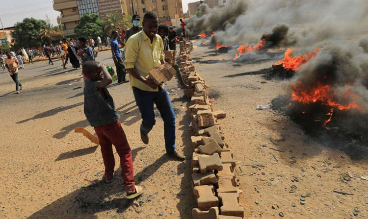 Người biểu tình Sudan đốt lốp xe chặn đường ở thủ đô Khartoum. Ảnh: AFP