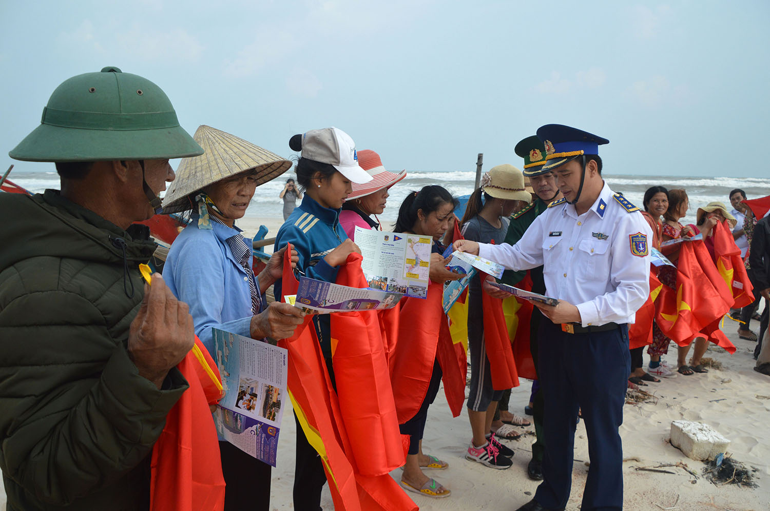 BTL Vùng Cảnh sát biển 1 cấp phát tờ rơi tuyên truyền cho bà con ngư dân vùng biển Ngư Thuỷ (Lệ Thủy).