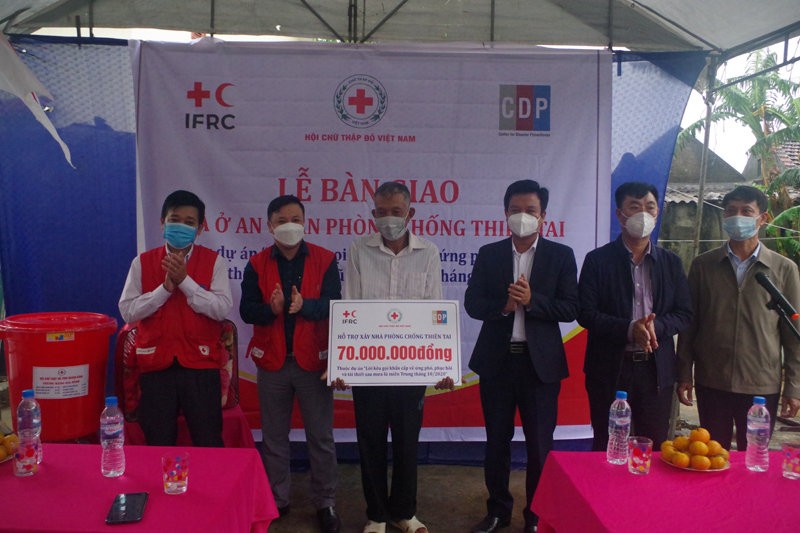 Các đại biểu trao bảng tượng trưng hỗ trợ “Nhà ở an toàn” cho hộ gia đình ở xã Tân Ninh.