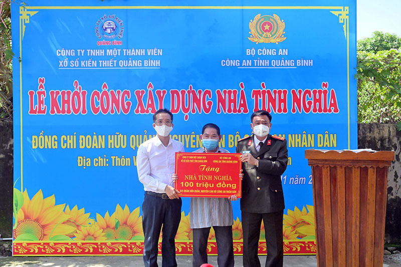 Đại diện Công an tỉnh và Công ty TNHH MTV Xổ số kiến thiết Quảng Bình trao tiền hỗ trợ xây nhà tình nghĩa cho ông Đoàn Hữu Quản.
