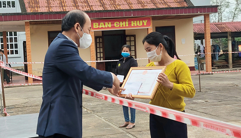 Đồng chí Chủ tịch UBND huyện Tuyên Hóa Lê Nam Giang trao giấy khen cho cô giáo Phan Thị Thảo Quyên.