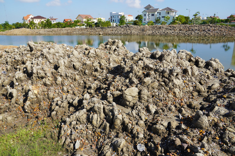 Hàng đống bùn đất được nạo vét lên để bên bờ sông Cầu Rào gây mất mỹ quan đô thị và ô nhiễm môi trường.