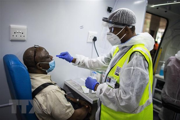 Nhân viên y tế lấy mẫu xét nghiệm COVID-19 cho người dân tại Ekurhuleni, Nam Phi. (Ảnh: AFP/TTXVN)