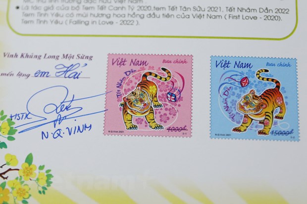 Người mua tem tại sự kiện được họa sỹ Nguyễn Quang Vinh ký tặng. (Ảnh: Hoài Nam/Vietnam)