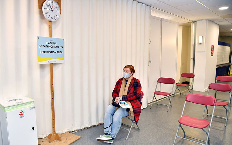 Người phụ nữ ngồi trong khu vực theo dõi sau khi tiêm chủng tại Đại học Dublin, Ireland. (Ảnh: Reuters)