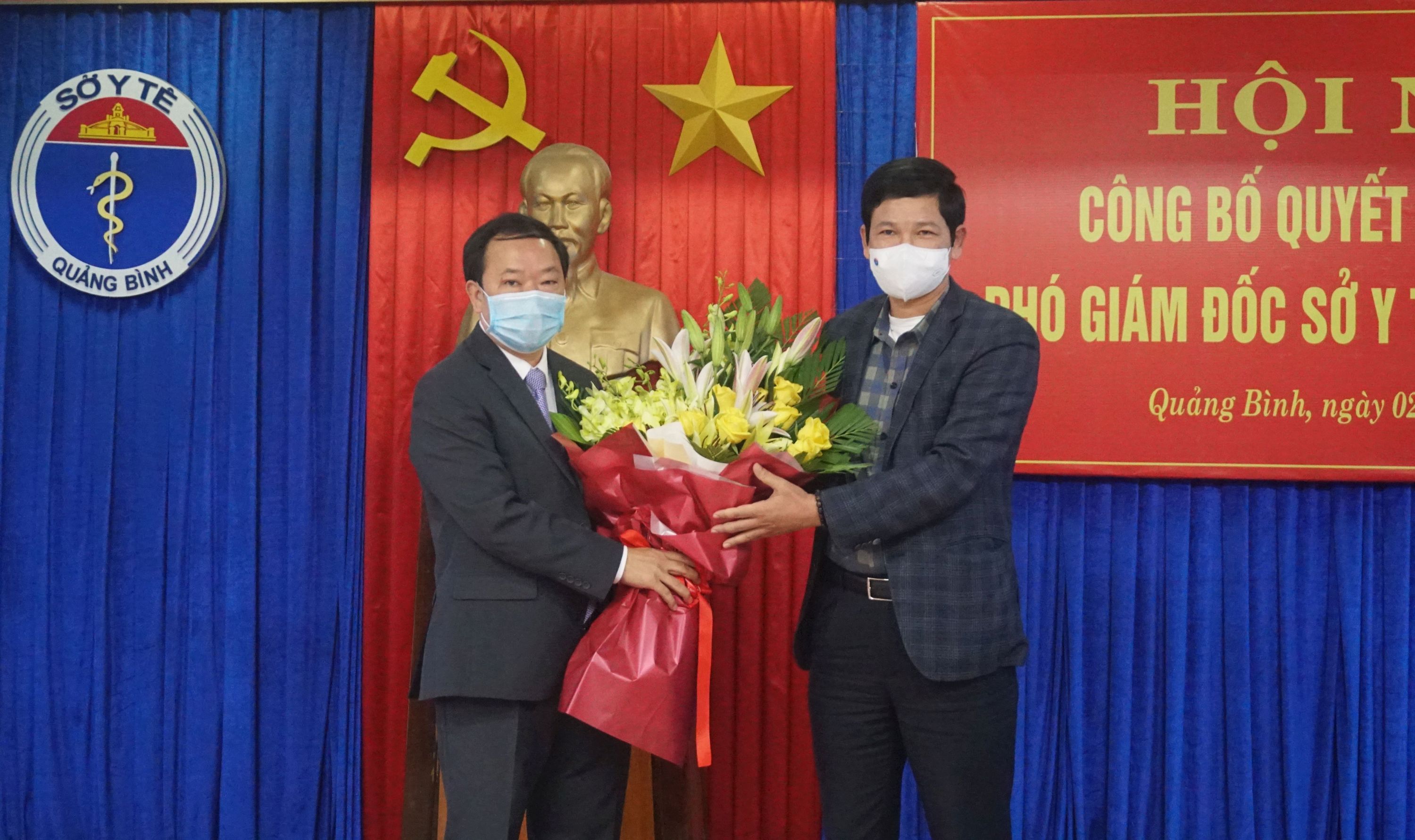 Đồng chí Phó Chủ tịch UBND tỉnh Hồ An Phong tặng hoa chúc mừng Phó Giám đốc Sở Y tế Đinh Viễn Anh.