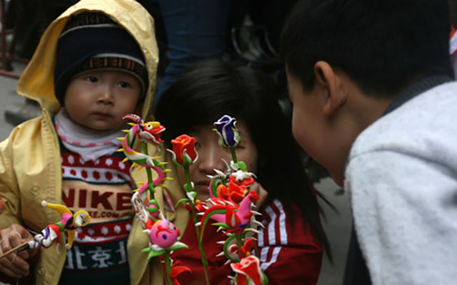   Em bé thích thú với các loại tò he ở một hội chợ quê truyền thống.
