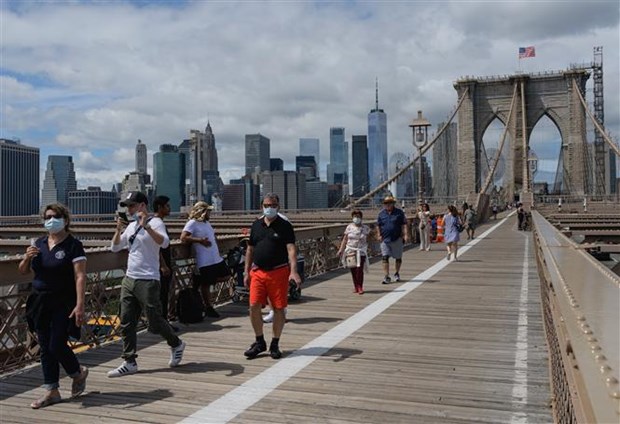  Người dân đeo khẩu trang phòng dịch COVID-19, trên cầu Brooklyn ở New York (Mỹ). (Ảnh: AFP/TTXVN)