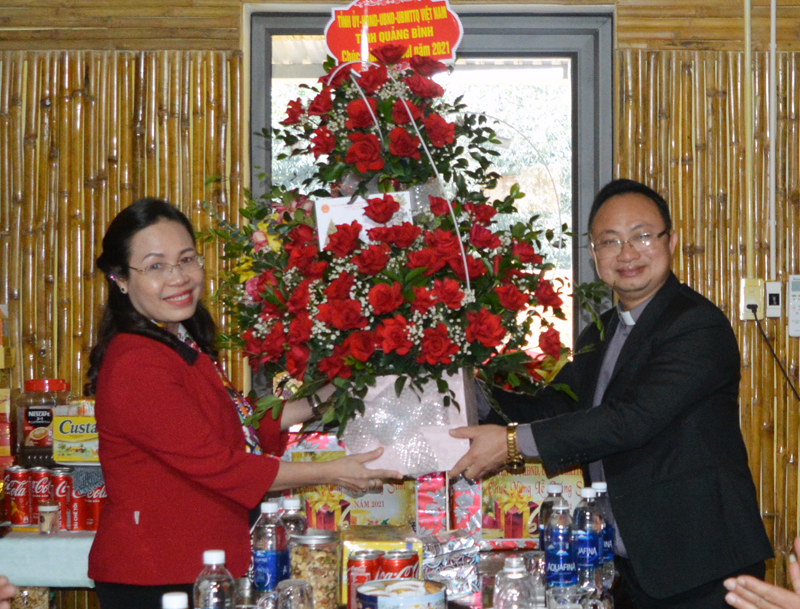 Đồng chí Chủ tịch Ủy ban MTTQVN tỉnh Phạm Thị Hân tặng hoa, quà cho Linh mục Võ Minh Danh, Hội đồng mục vụ và bà con giáo họ Bàu Sen.