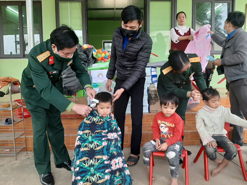 Cán bộ nhân viên Ban CHQS huyện  cắt tóc cho trẻ mầm non tại điểm trường bản Cáo
