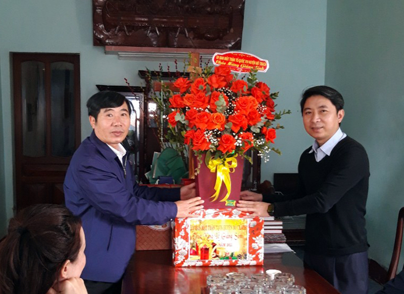 Đồng chí Chủ tịch Ủy ban MTTQVN huyện Bố Trạch Lê Duy Hưng tặng hoa chúc mừng linh mục quản xứ Gia Hưng Nguyễn Văn Hùng.