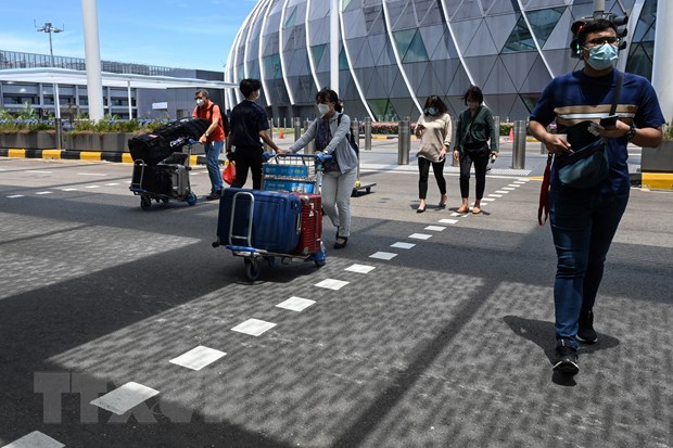 Hành khách đeo khẩu trang phòng dịch COVID-19 tại sân bay quốc tế Changi, Singapore. (Ảnh: AFP/TTXVN)
