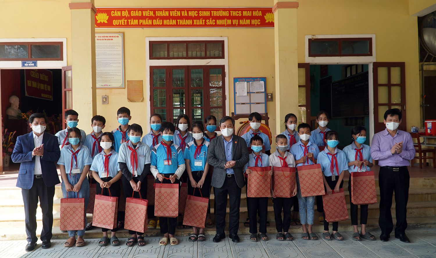 Các đồng chí trong đoàn công tác tặng quà cho học sinh Trường THCS Mai Hóa.