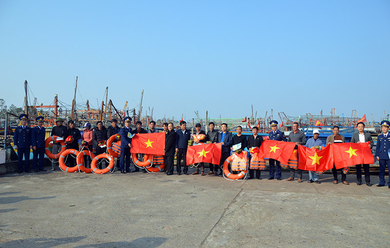 Lực lượng Cảnh sát biển tặng cờ Tổ quốc cho bà con ngư dân ở Khu neo đậu tránh trú bão cho tàu cá cửa Gianh (xã Bắc Trạch, Bố Trạch).