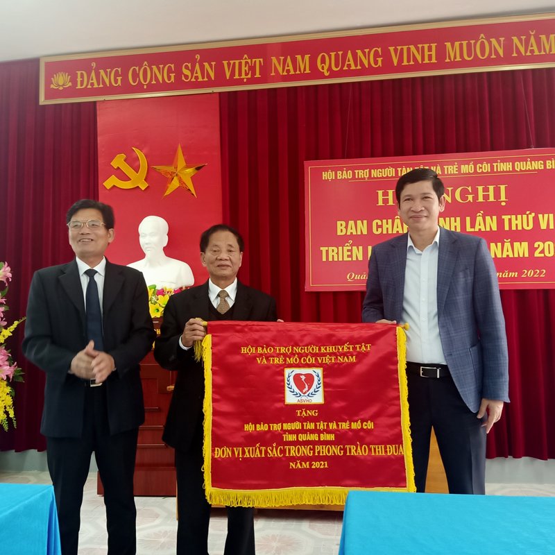 Đồng chí Hồ An Phong, TUV, Phó Chủ tịch UBND tỉnh thay mặt lãnh đạo tỉnh trao Cờ thi đua của Hội BTNKT và TMC Việt Nam cho Hội bảo trợ người tàn tật và trẻ mồ côi tỉnh