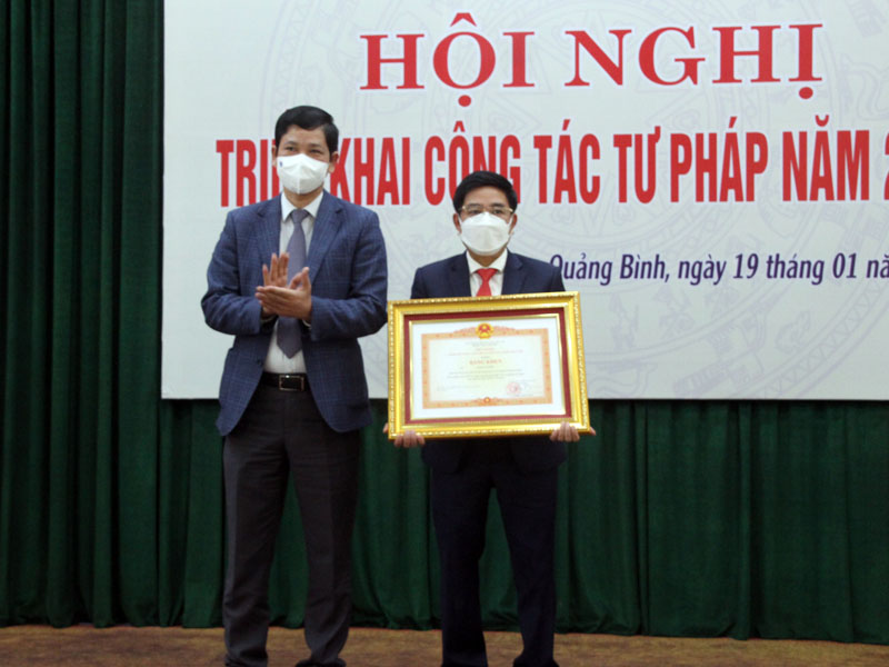 Đồng chí Hồ An Phong trao Bằng khen của Thủ tướng Chính phủ cho ông Phạm Lê Sơn, Giám đốc Trung tâm dịch vụ đấu giá tài sản, Sở Tư pháp