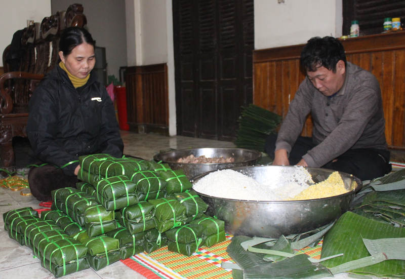 Vợ chồng anh Hoàng Minh Hải (phường Đức Ninh Đông, TP. Đồng Hới) cẩn thận từ khâu chuẩn bị nguyên liệu đến khâu gói bánh chưng.