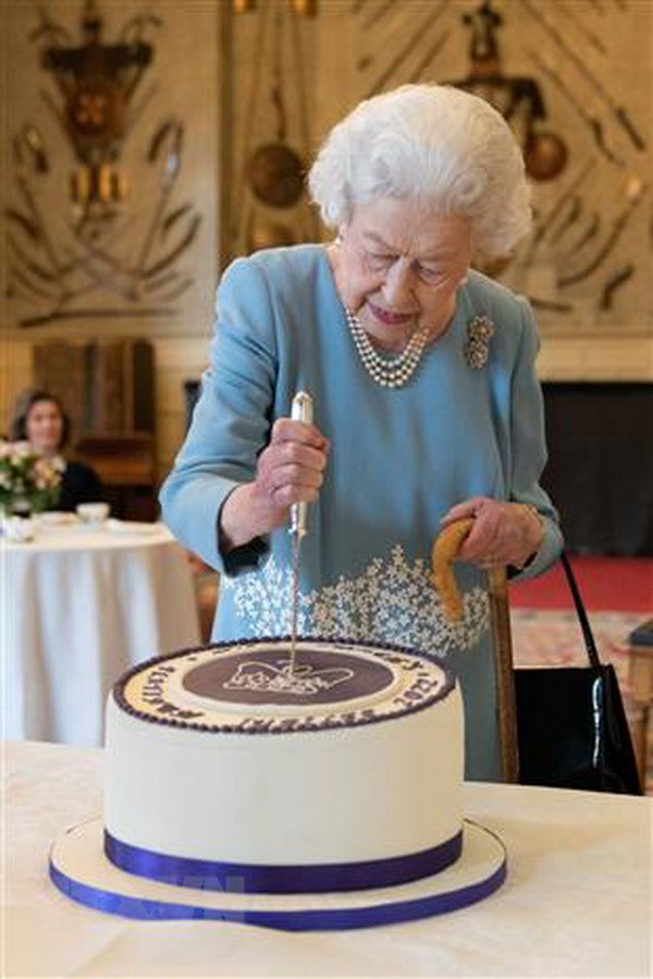 Nữ Hoàng Elizabeth II cắt bánh trong Đại lễ Bạch kim tại dinh thự Sandringham, phía Đông vùng England ngày 6/2/2022. (Ảnh: AFP/TTXVN)