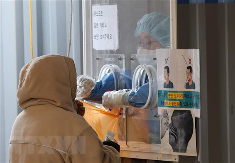 Nhân viên y tế lấy mẫu xét nghiệm COVID-19 cho người dân tại Seoul, Hàn Quốc ngày 23/1/2022. (Ảnh: Yonhap/TTXVN)