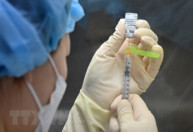Nhân viên y tế chuẩn bị mũi tiêm vaccine phòng COVID-19. (Ảnh: AFP/TTXVN)