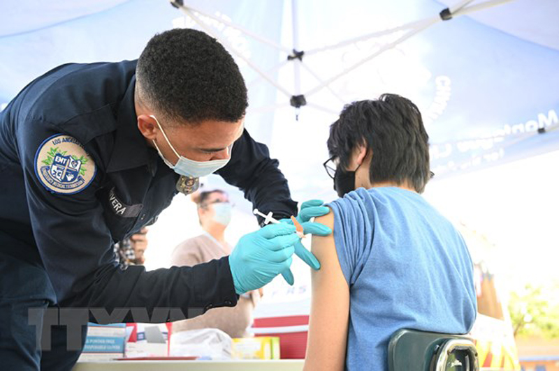 Nhân viên y tế tiêm vaccine phòng COVID-19 của hãng Pfizer-BioNTech cho trẻ em tại Los Angeles, California, Mỹ. (Ảnh: AFP/TTXVN)