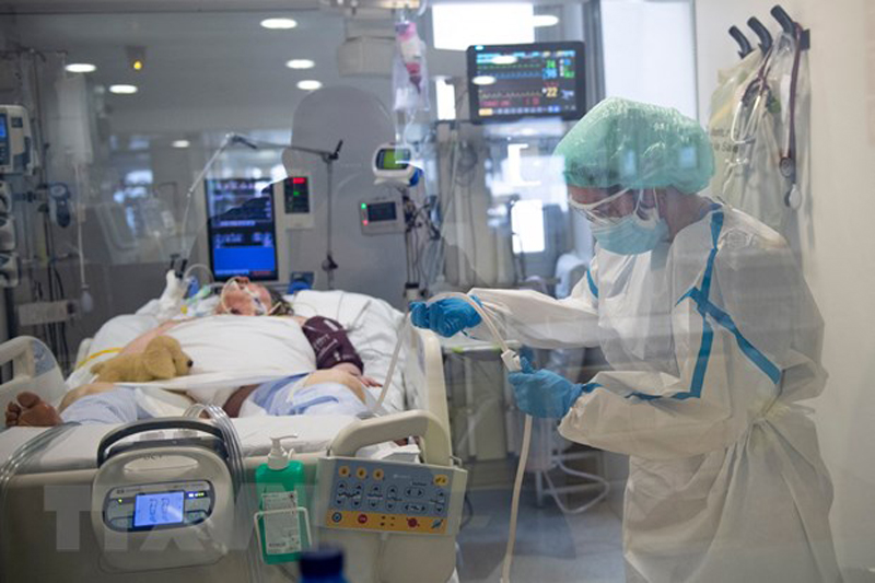 Nhân viên y tế điều trị cho bệnh nhân COVID-19. (Ảnh: AFP/TTXVN)