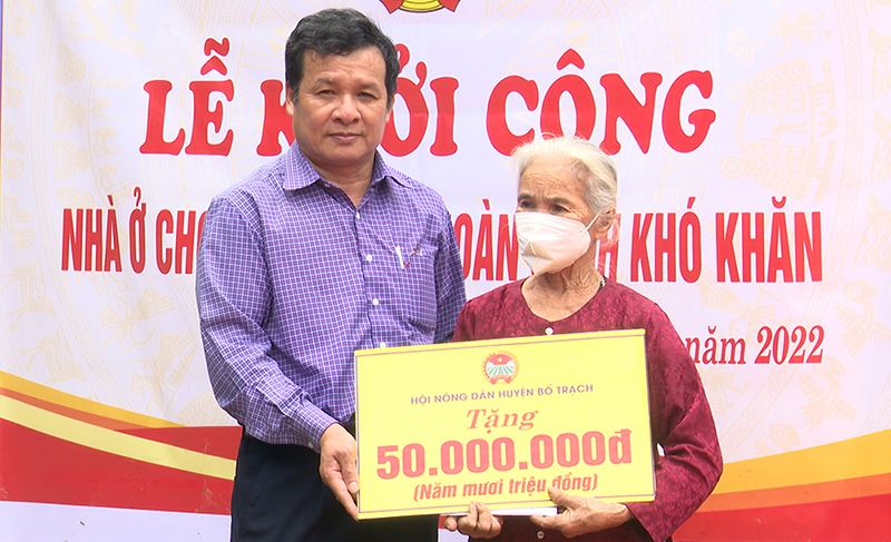 Đại diện lãnh đạo Hội Nông dân huyện Bố Trạch trao tiền hỗ trợ xây nhà ở cho bà Nguyễn Thị Mai.