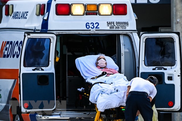 Nhân viên y tế chuyển bệnh nhân nhiễm COVID-19 tới bệnh viện ở Miami, Mỹ. (Ảnh: AFP/TTXVN)