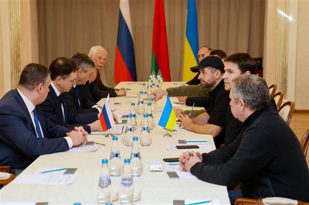 Các thành viên phái đoàn Nga (trái) và Ukraine tại vòng đàm phán ở vùng Gomel, Belarus, ngày 28/2/2022. (Ảnh: AFP/TTXVN)