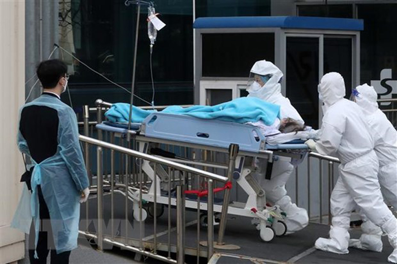 Nhân viên y tế chuyển bệnh nhân COVID-19 tới bệnh viện ở Seoul, Hàn Quốc. (Ảnh: THX/TTXVN)