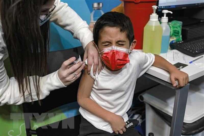 Nhân viên y tế Israel tiêm vaccine phòng COVID-19 của Pfizer/BioNTech cho trẻ em tại Jerusalem ngày 23/11/2021. (Ảnh: AFP/TTXVN)