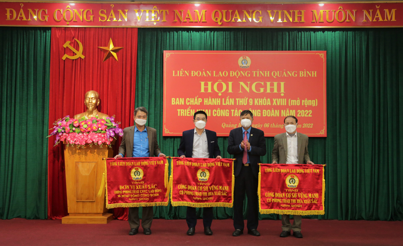 Đại diện lãnh đạo LĐLĐ huyện Quảng Trạch (ngoài cùng bên trái) nhận cờ đơn vị xuất sắc do Tổng LĐLĐ Việt Nam trao tặng.