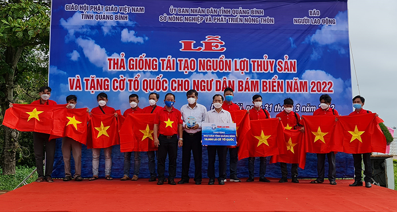 Đồng chí Phó Chủ tịch Thường trực UBND tỉnh Đoàn Ngọc Lâm và lãnh đạo Báo Người lao động trao tặng cờ Tổ quốc và túi thuốc y tế cho ngư dân.