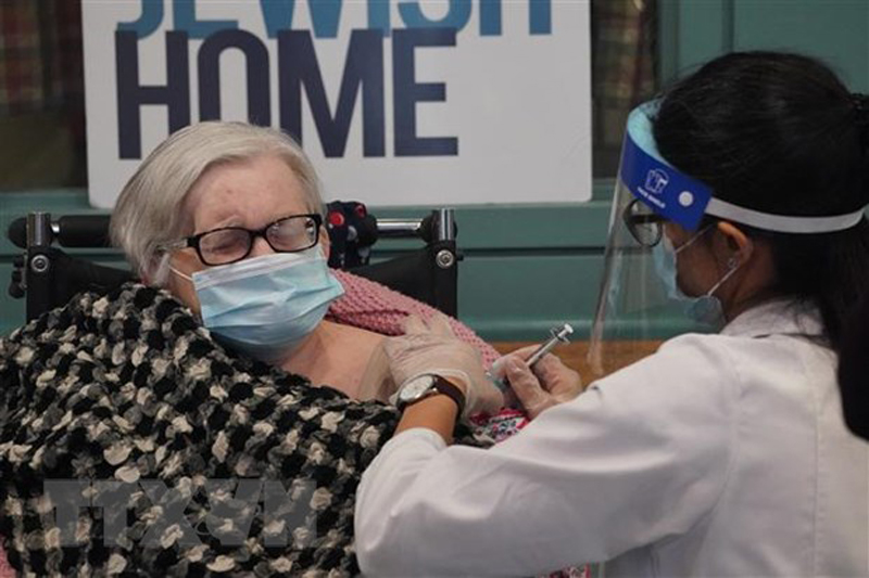 Nhân viên y tế tiêm vaccine phòng COVID-19 của Pfizer/BioNTech cho người cao tuổi tại New York, Mỹ. (Ảnh: AFP/TTXVN)