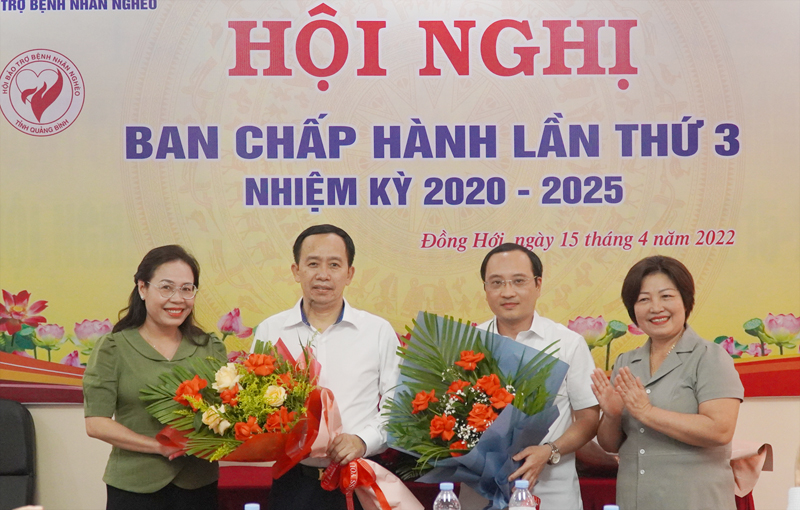 Đồng chí Chủ tịch Ủy ban MTTQVN tỉnh Phạm Thị Hân tặng hoa chúc mừng tân Phó Chủ tịch và thành viên Ban Chấp hành Hội BTBNN Quảng Bình.