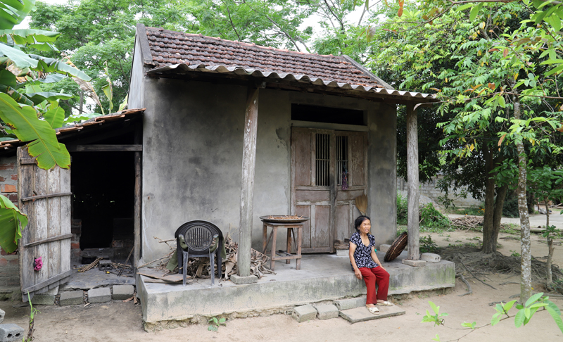 Mệ Nguyễn Thị Khảnh trước căn nhà nhỏ dột nát.