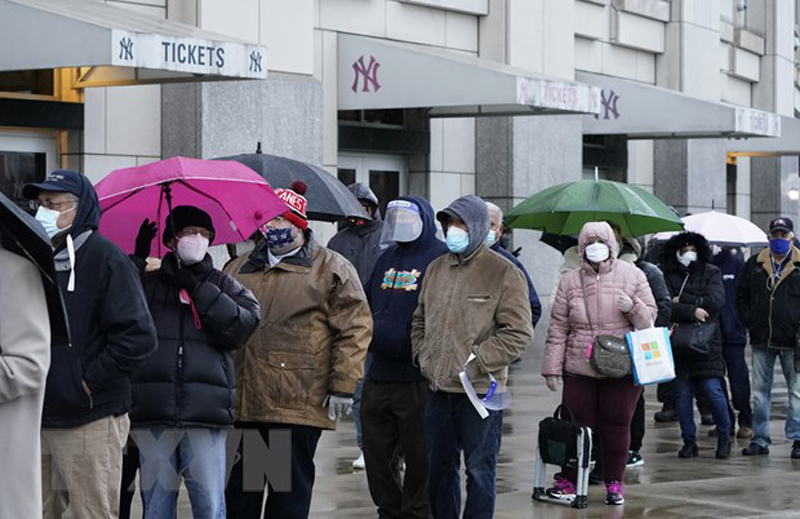Người dân đeo khẩu trang phòng lây nhiễm COVID-19 tại một điểm tiêm chủng ở New York, Mỹ. (Ảnh: AFP/TTXVN)