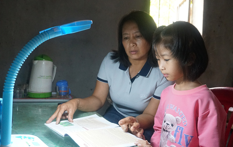 Các “Mẹ đỡ đầu” ở Hội LHPN xã Quảng Hưng giúp em Bùi Hương Mai học bài.