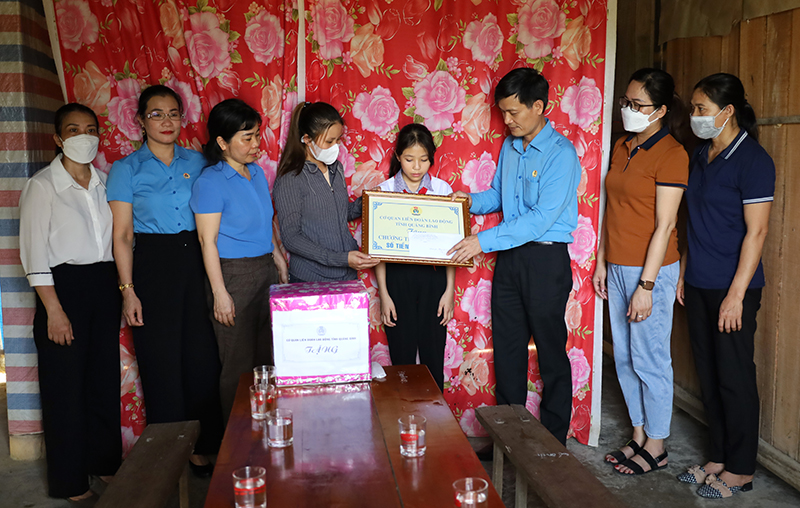 Đại diện lãnh đạo LĐLĐ tỉnh trao số tiền hỗ trợ thực hiện chương trình “Mẹ đỡ đầu” cho Cháu Trần Hà Vy, xã Kim Hóa (Tuyên Hóa).