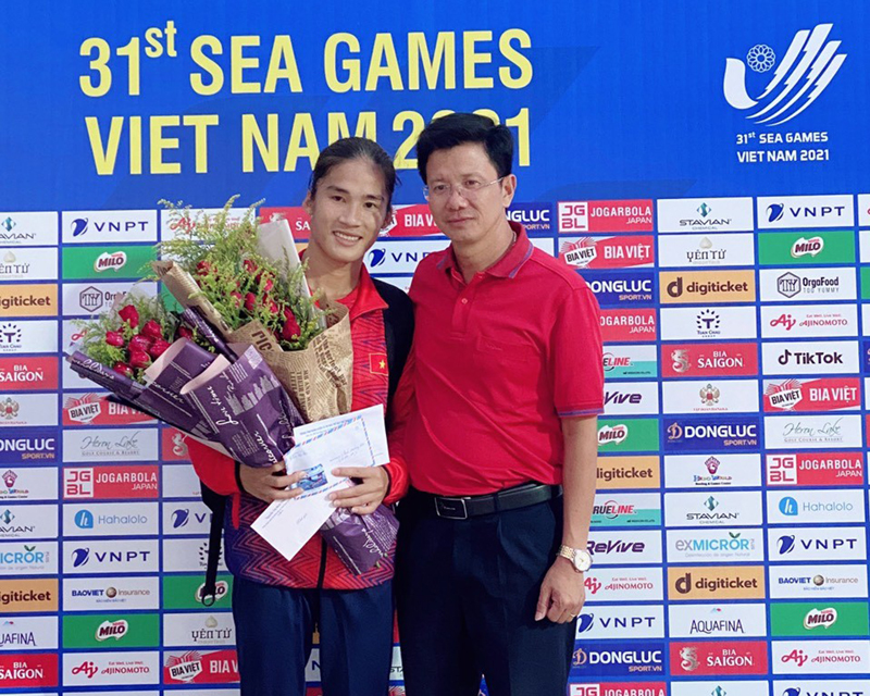 Ông Nguyễn Văn Tuynh, Giám đốc Trung tâm huấn luyện và thi đấu TDTT tỉnh Quảng Bình tặng hoa chúc mừng VĐV Nguyễn Thị Hương.