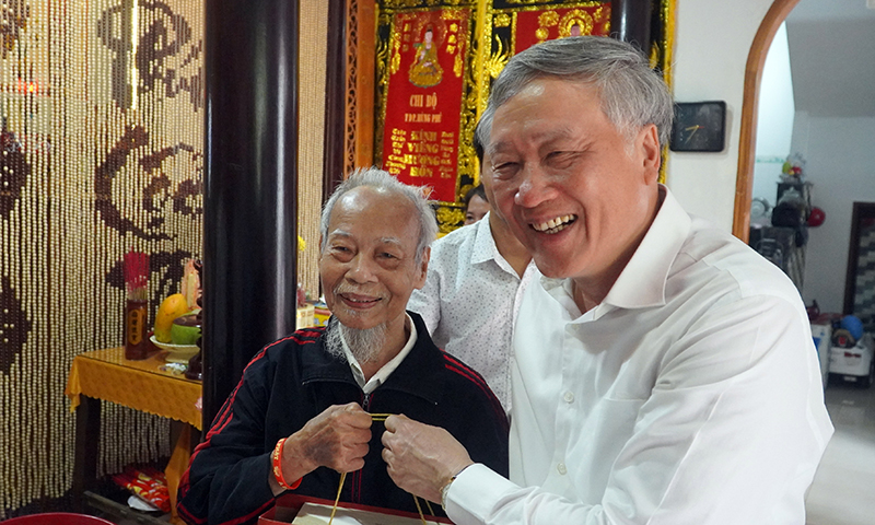 Đồng chí Nguyễn Hòa Bình tặng quà và chúc ông Mai Xuân Tấn luôn sống vui, sống khỏe