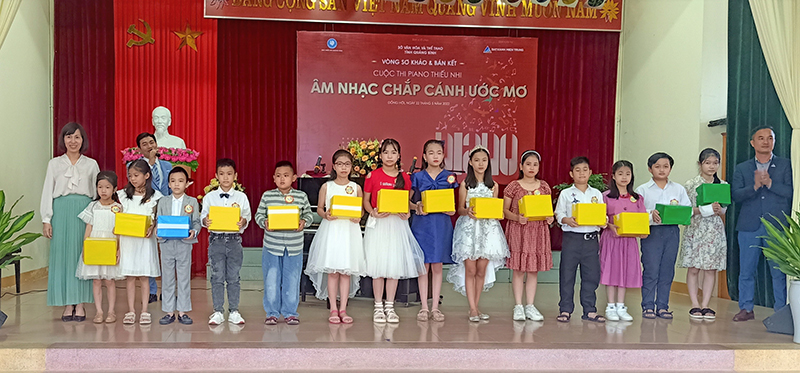 Các thí sinh nhận quà lưu niệm của ban tổ chức tại cuộc thi Piano thiếu nhi “Âm nhạc chắp cánh ước mơ” năm 2022.