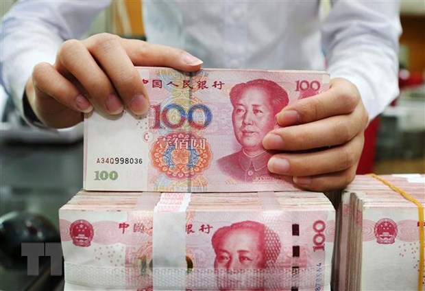 Kiểm tiền mệnh giá 100 nhân dân tệ tại một ngân hàng ở tỉnh Giang Tô, Trung Quốc. (Ảnh: AFP/TTXVN)