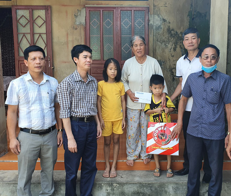 Đại diện lãnh đạo Báo Quảng Bình và chính quyền xã Trường Thủy (Lệ Thủy) trao quà và tiền hỗ trợ cho cháu Nguyễn Anh Đô La và Nguyễn Võ Tường Vy.