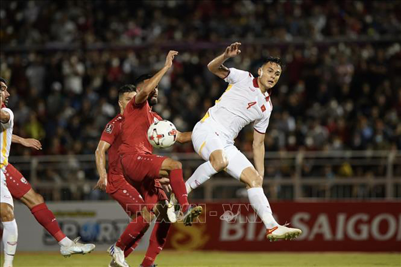 Pha tranh bóng giữa các tuyển thủ Việt Nam (áo trắng) với các cầu thủ Afghanistan (áo đỏ) Ảnh: Thanh Vũ/TTXVN