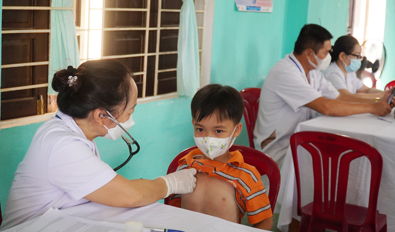Các em học sinh được cán bộ y tế khám sàng lọc rất kỹ trước khi tiêm vắc xin phòng Covid-19.