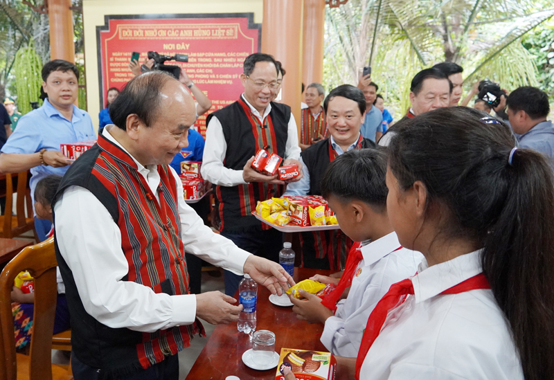 Chủ tịch nước Nguyễn Xuân Phúc phát kẹo bánh cho các em học sinh đồng bào dân tộc thiểu số.
