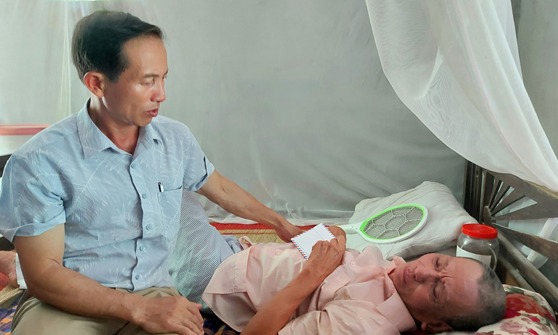 Anh Mai Văn Hóa trao quà, động viên một người dân trong thôn bị bệnh.